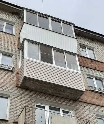 Нестандартный балкон с обшивкой коричневым сайдингом