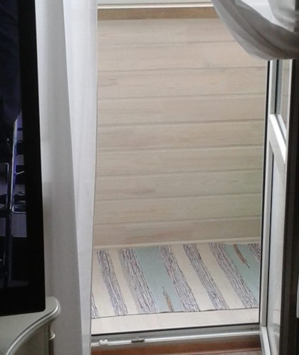 Нестандартный балкон с обшивкой коричневым сайдингом