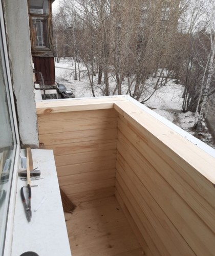 Нестандартный балкон с обшивкой коричневым сайдингом