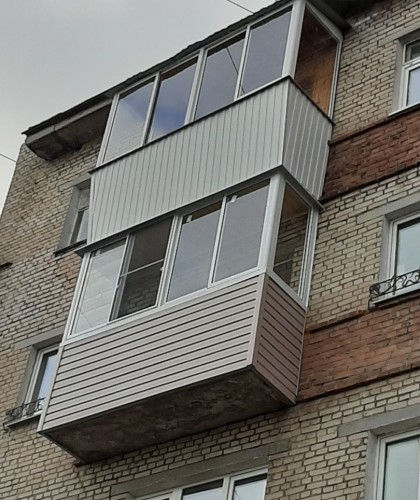 Нестандартный балкон с обшивкой коричневым сайдингом