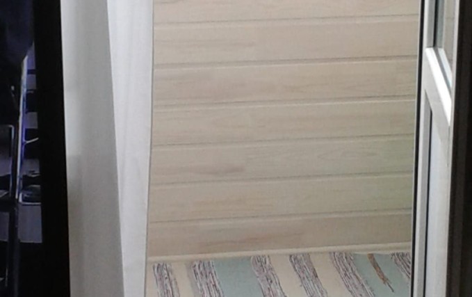 Нестандартный балкон с обшивкой коричневым сайдингом