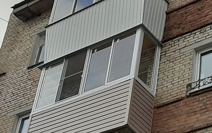 Нестандартный балкон с обшивкой коричневым сайдингом 3
